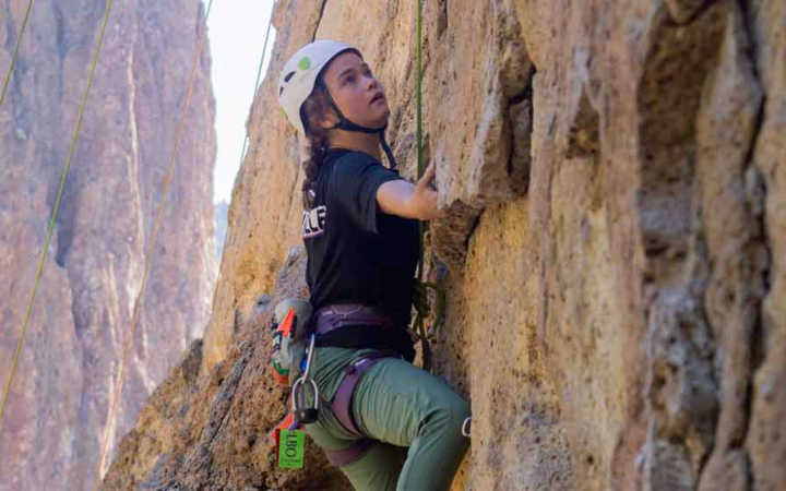 girl navigates route while rock climbing